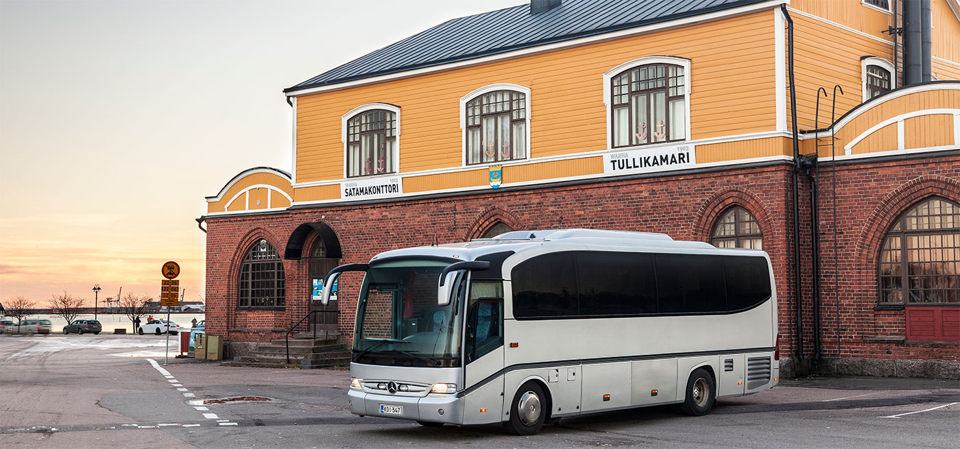 Harmaa tilausajobussi pysäköityneenä